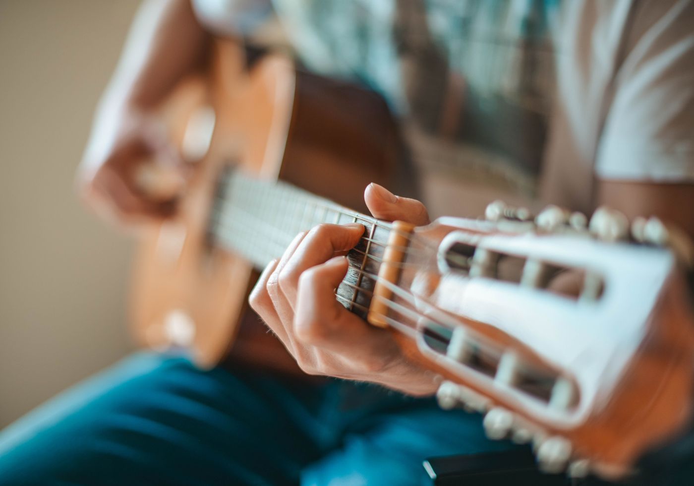 Close-up of hands shaping a chord on an acoustic guitar
